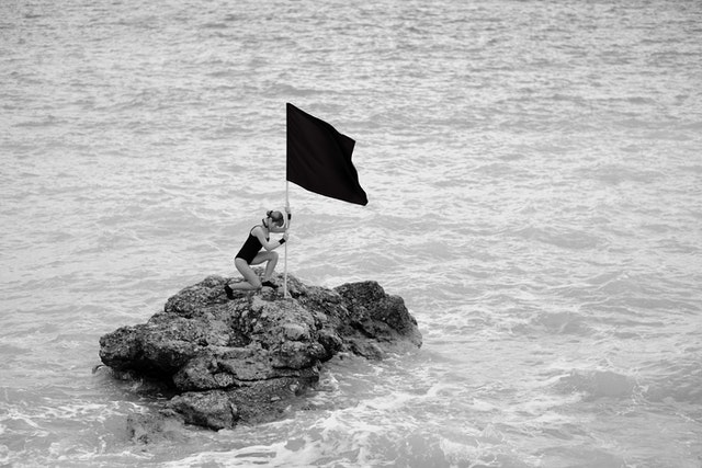 beach, Photo by Engin Akyurt: https://www.pexels.com/photo/woman-on-rock-formation-holding-a-flag-1493210/