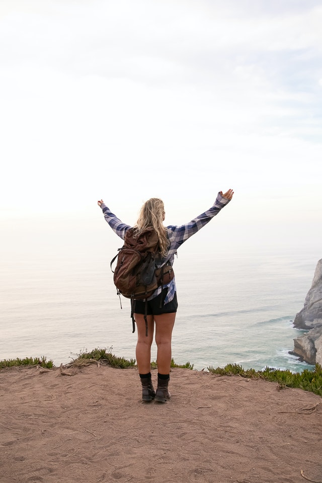 Photo by Kampus Production: https://www.pexels.com/photo/woman-standing-on-cliff-with-arms-raised-5937317/, travel