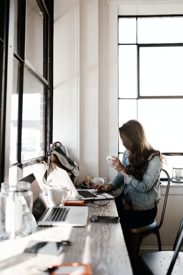 Woman with coffee in small office