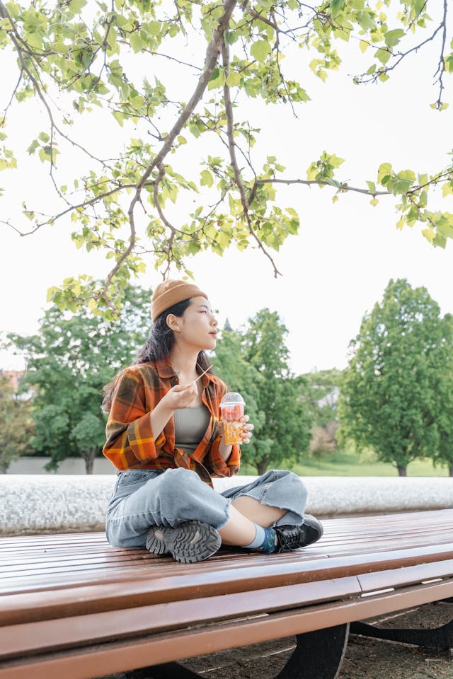 lady sitting on park bench with legs criss crossed