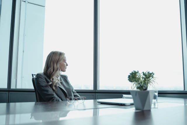 woman looking out the window sad from burnout