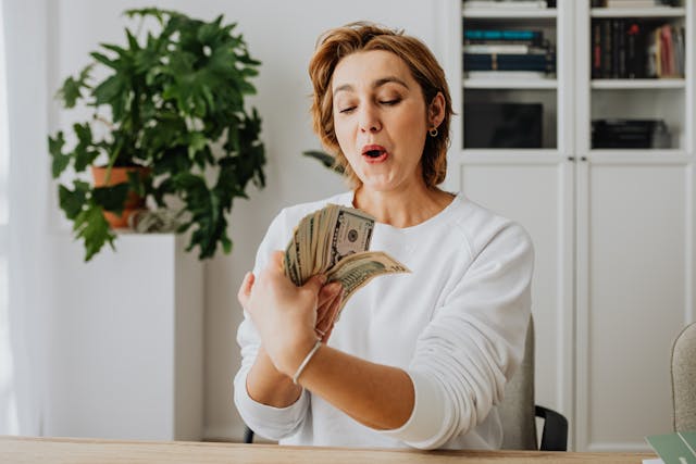 Woman counting her ebay money from selling through some of her death piles.